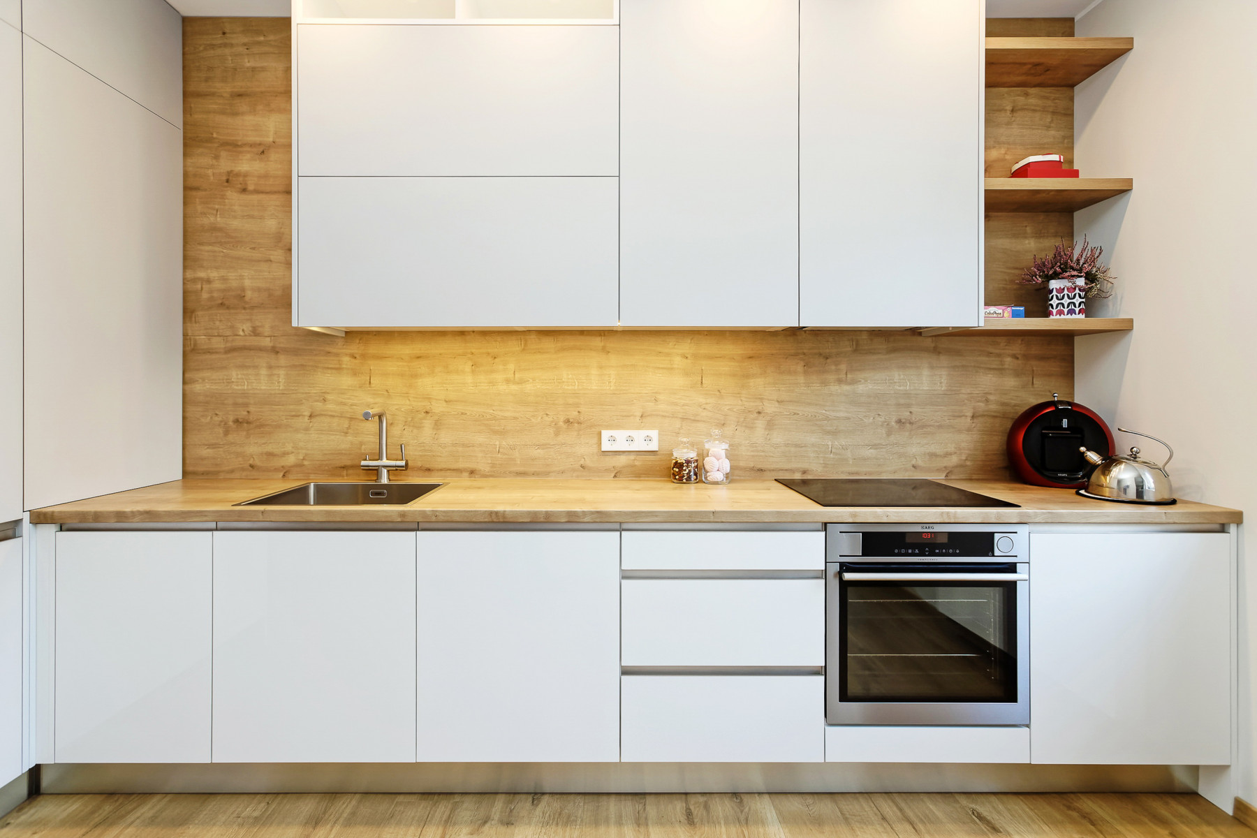 Virtuves mēbeles ar baltām un koka krāsas fasādēm.