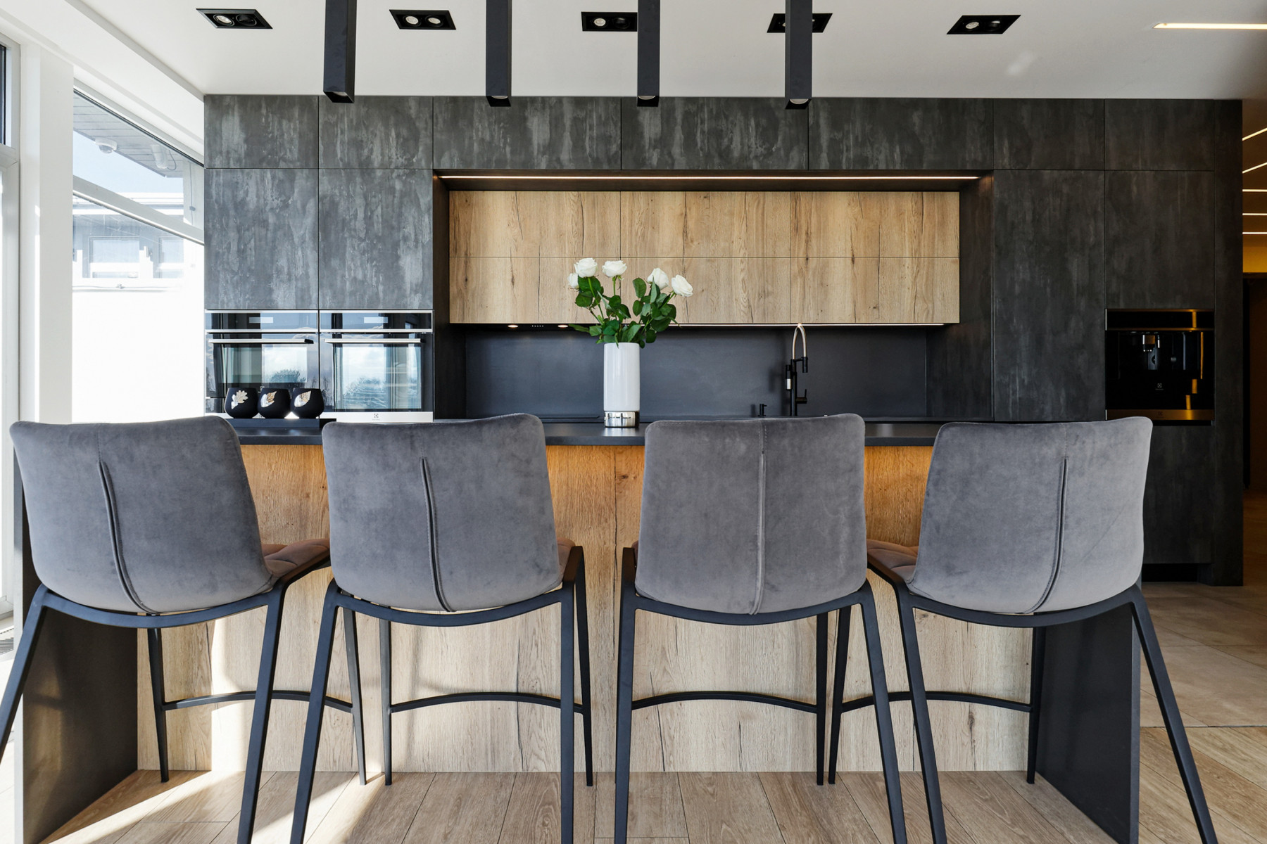 Stilīga virtuves sala ar pelēkiem regulējamiem krēsliem