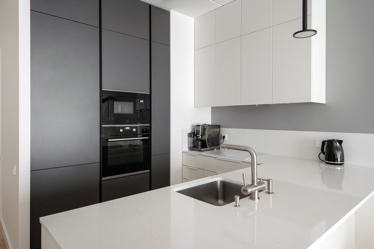Mūsu nesen radītā virtuves mēbeļu dizaina paraugs, kas ir uzstādīts Merks jaunajā projektā Rūpniecības ielā, apvienojot balto un tumši pelēko krāsu, eleganci un funkcionalitāti