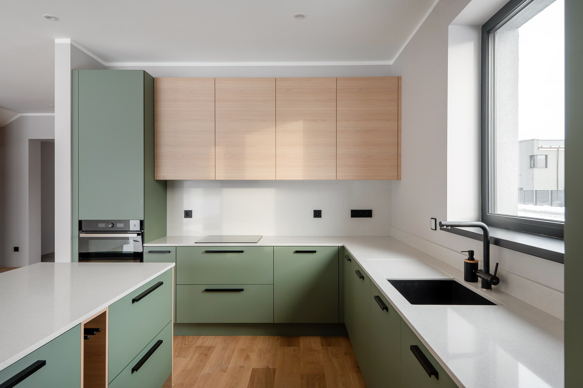 Stilīga virtuve ar akcentu uz tumši zaļām fasādēm, apvienojot funkcionālumu un modernu dizainu.